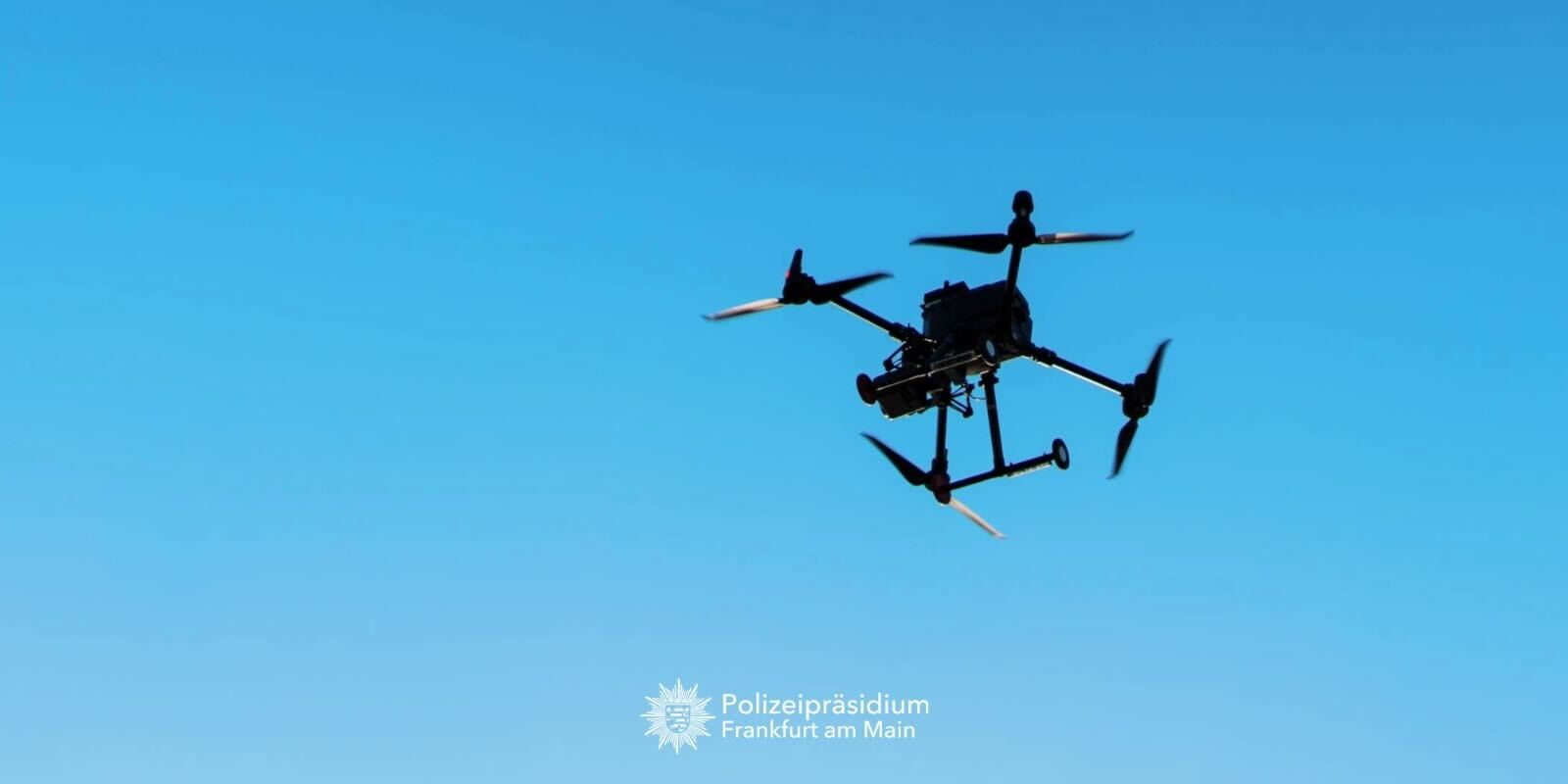Polizeidrohne vor blauem Himmel.