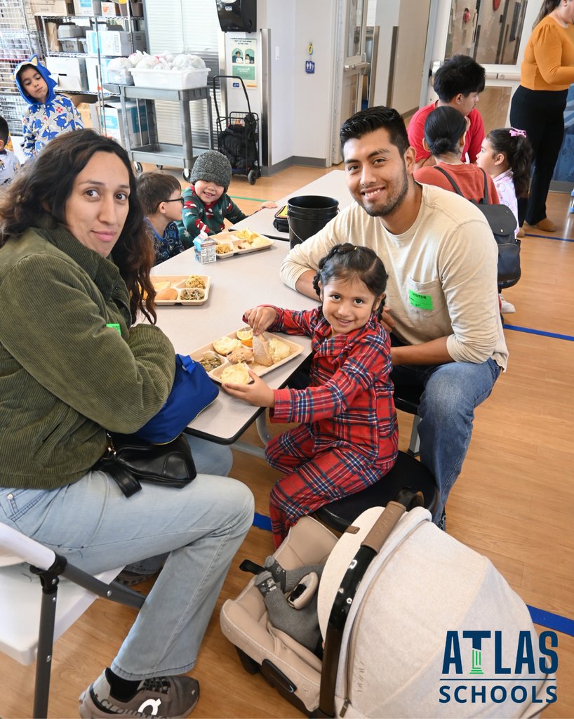 family sits at table with food