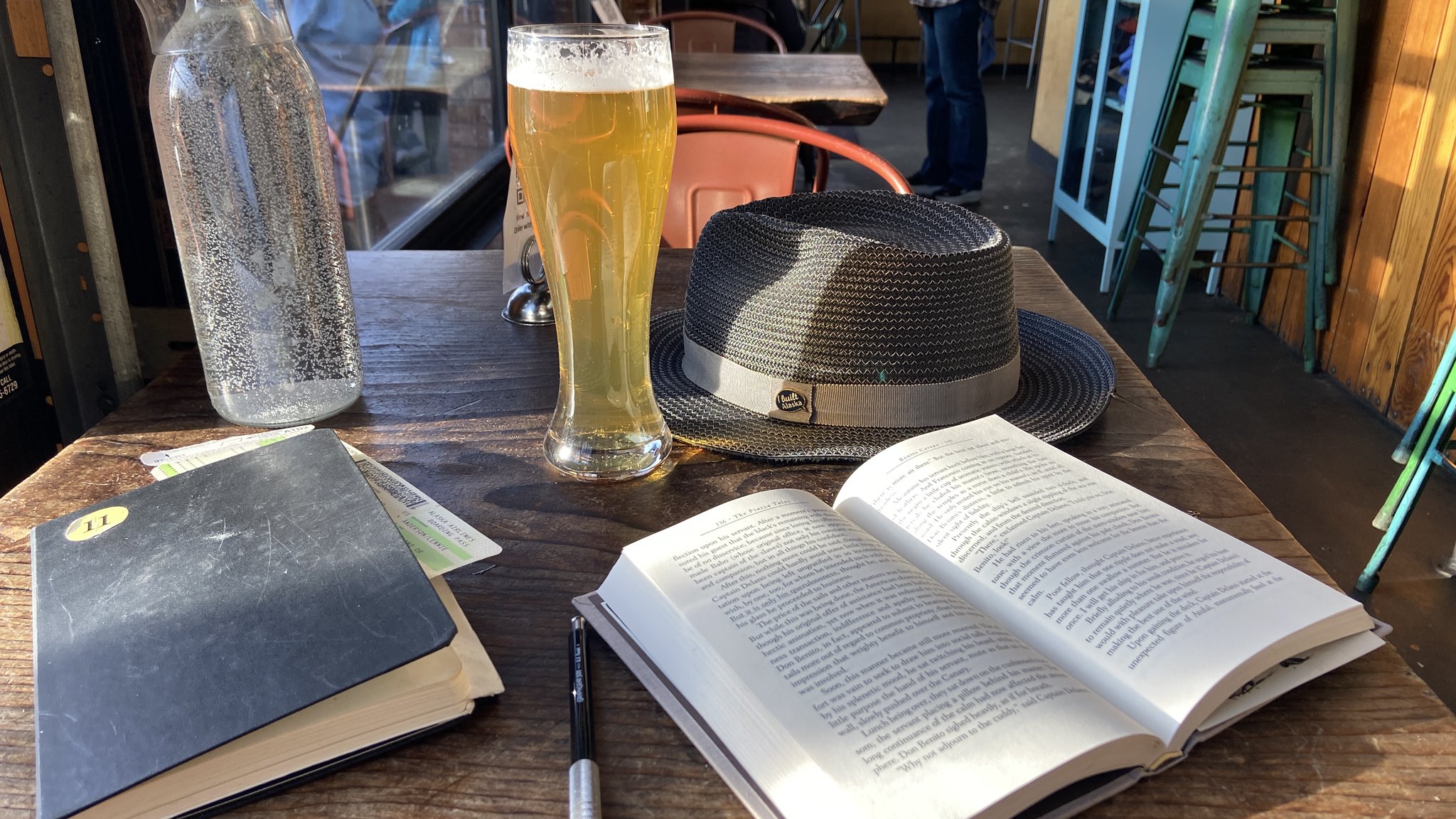 Mon journaux, le livre Piazza Tales de Joseph Conrad, un bière frais, mon bon chapeau gris.