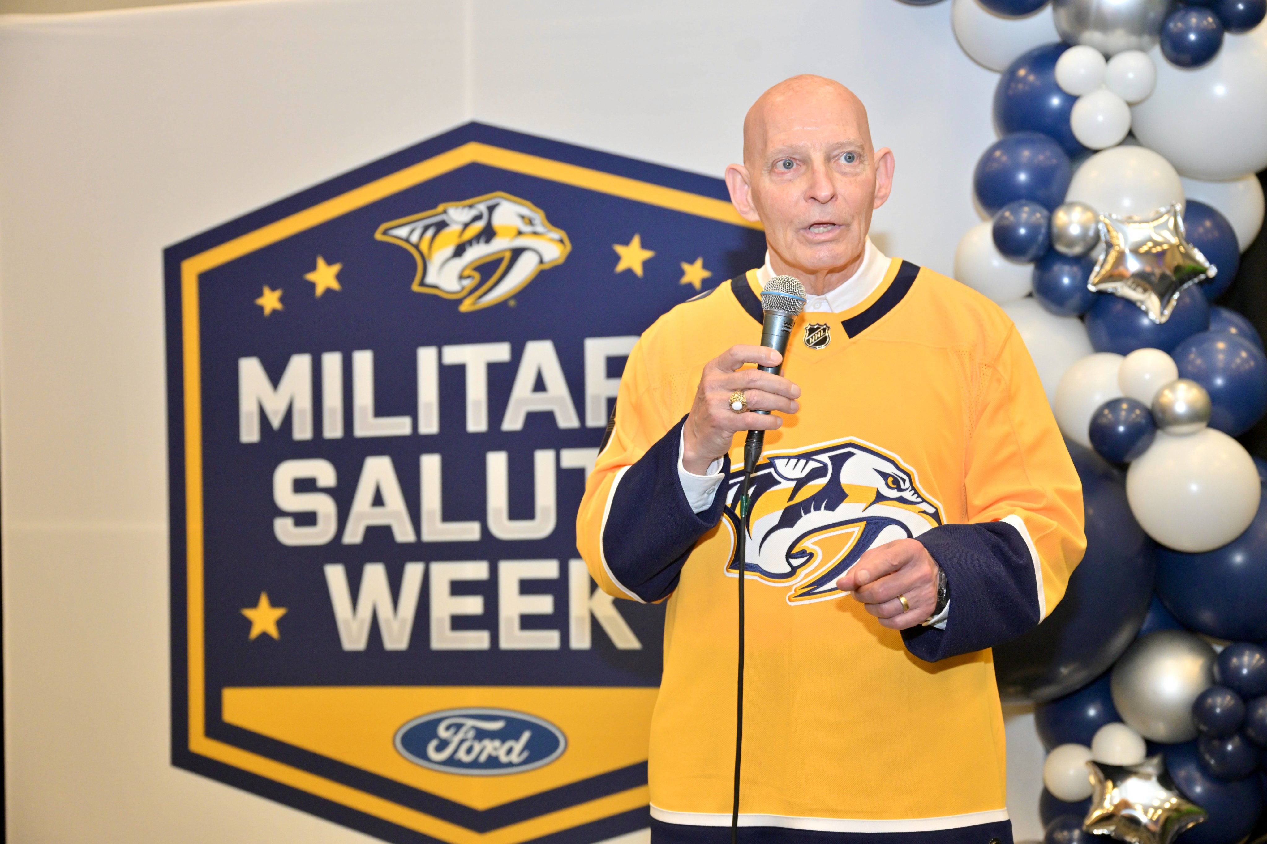 Army LTG(R) Keith Huber holding a microphone at the Nashville Predators Military Salute Week event
