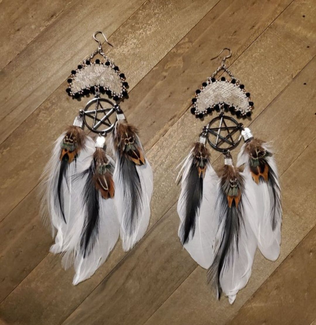 moon shaped earrings made with salmon skin and beaded edges, metal pentacles and feathers in shades of white and brown