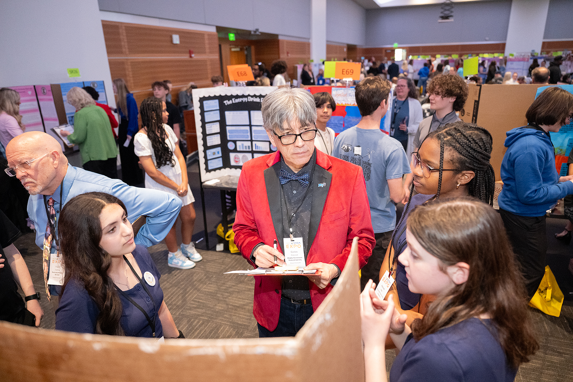 MTSU's Carlos Coronel listening to students present their project at the RCS STEM Expo