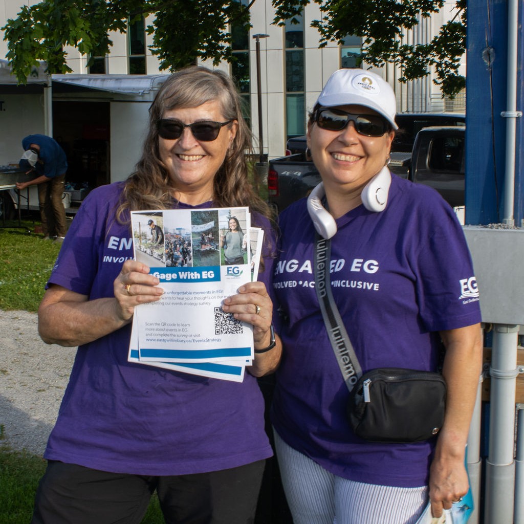 Two people wearing Engaged EG shirts smiling into the camera.