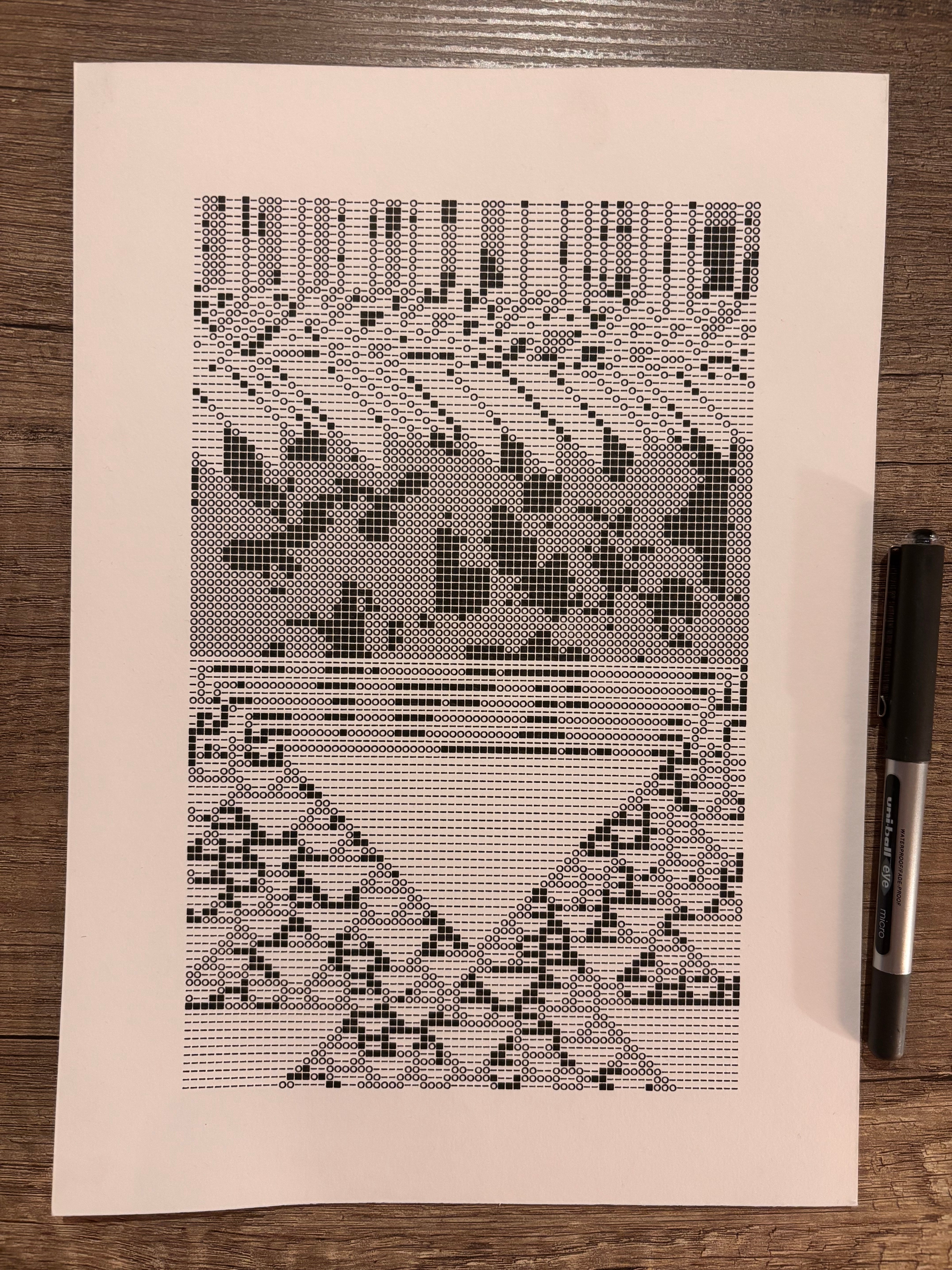 Black and white abstract pattern with geometric shapes, including lines and grids, printed on paper with a pen beside it