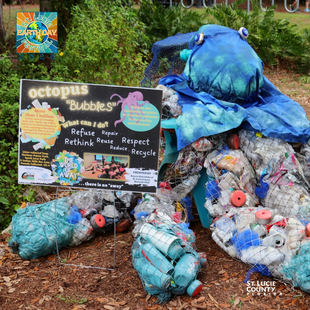 Large octopus sculpture made from recycled plastic bottles and trash, promoting reuse and recycling at an Earth Day festival.
