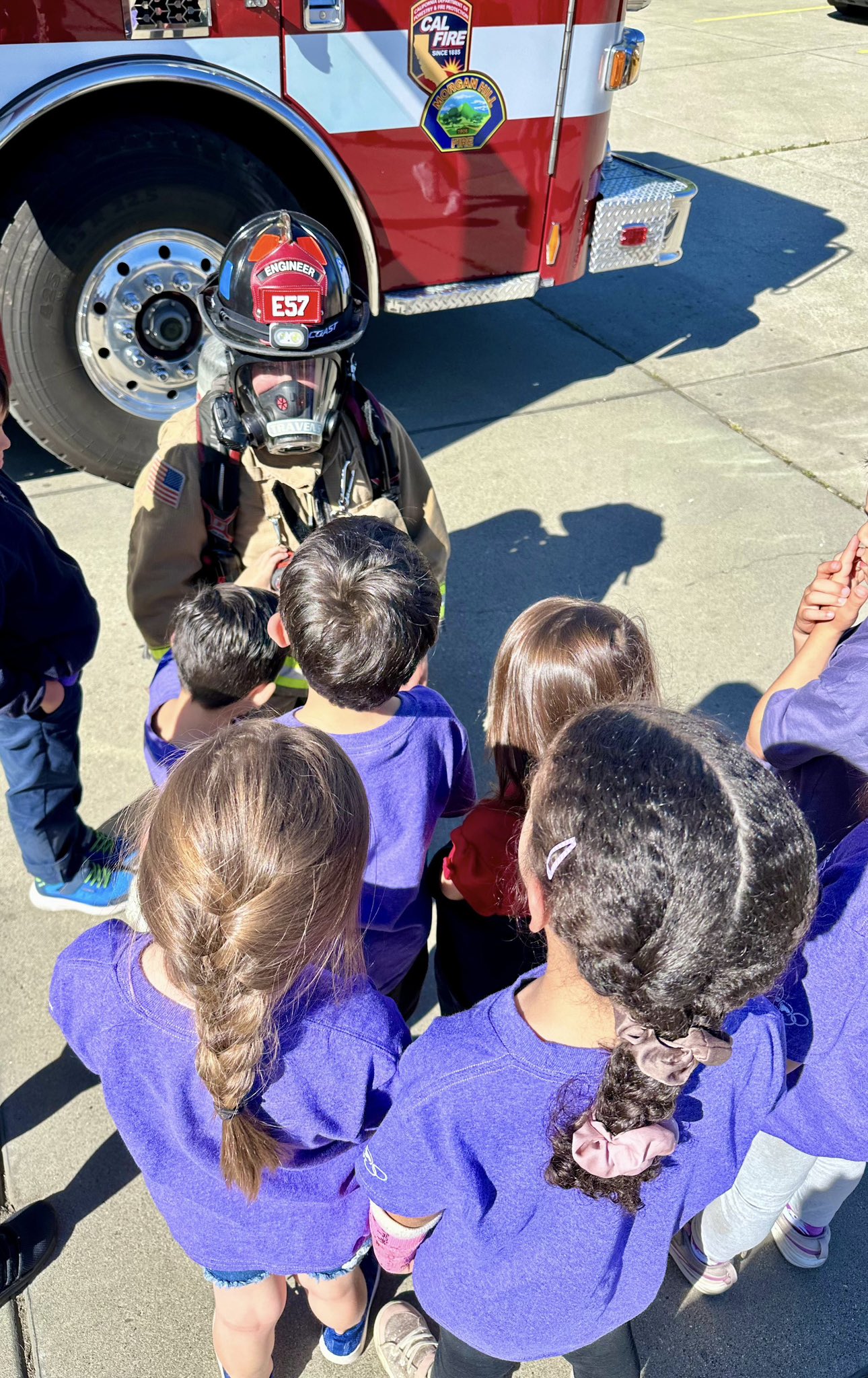 A firefighter wearing a self contained breathing apparatus showing school students what it looks like