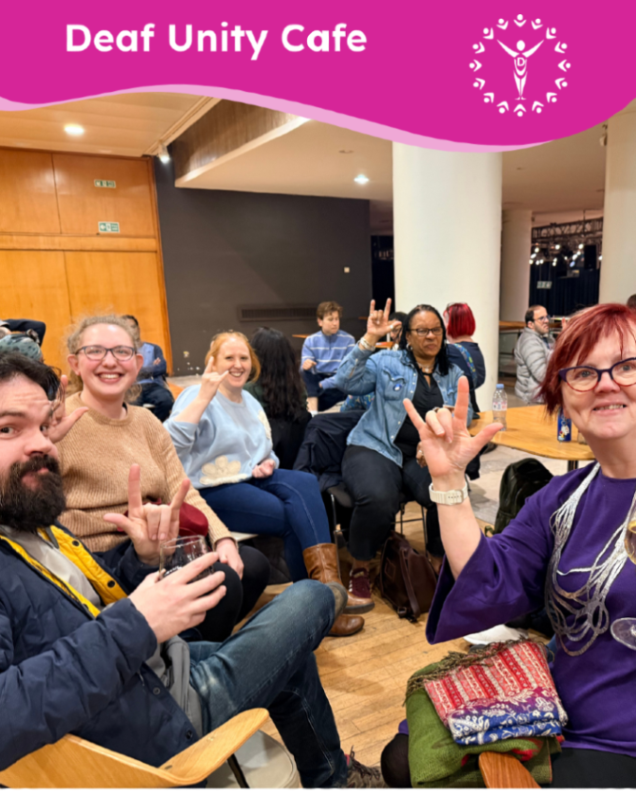 Smiling group seated at Deaf Unity Cafe