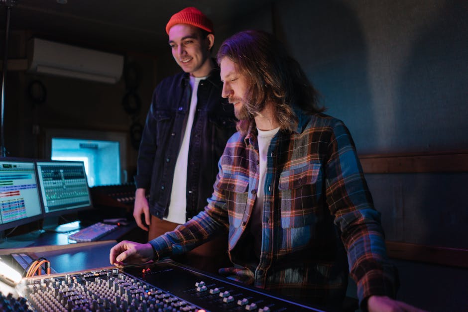 Two sound engineers collaborate at a mixing console in a professional music studio.