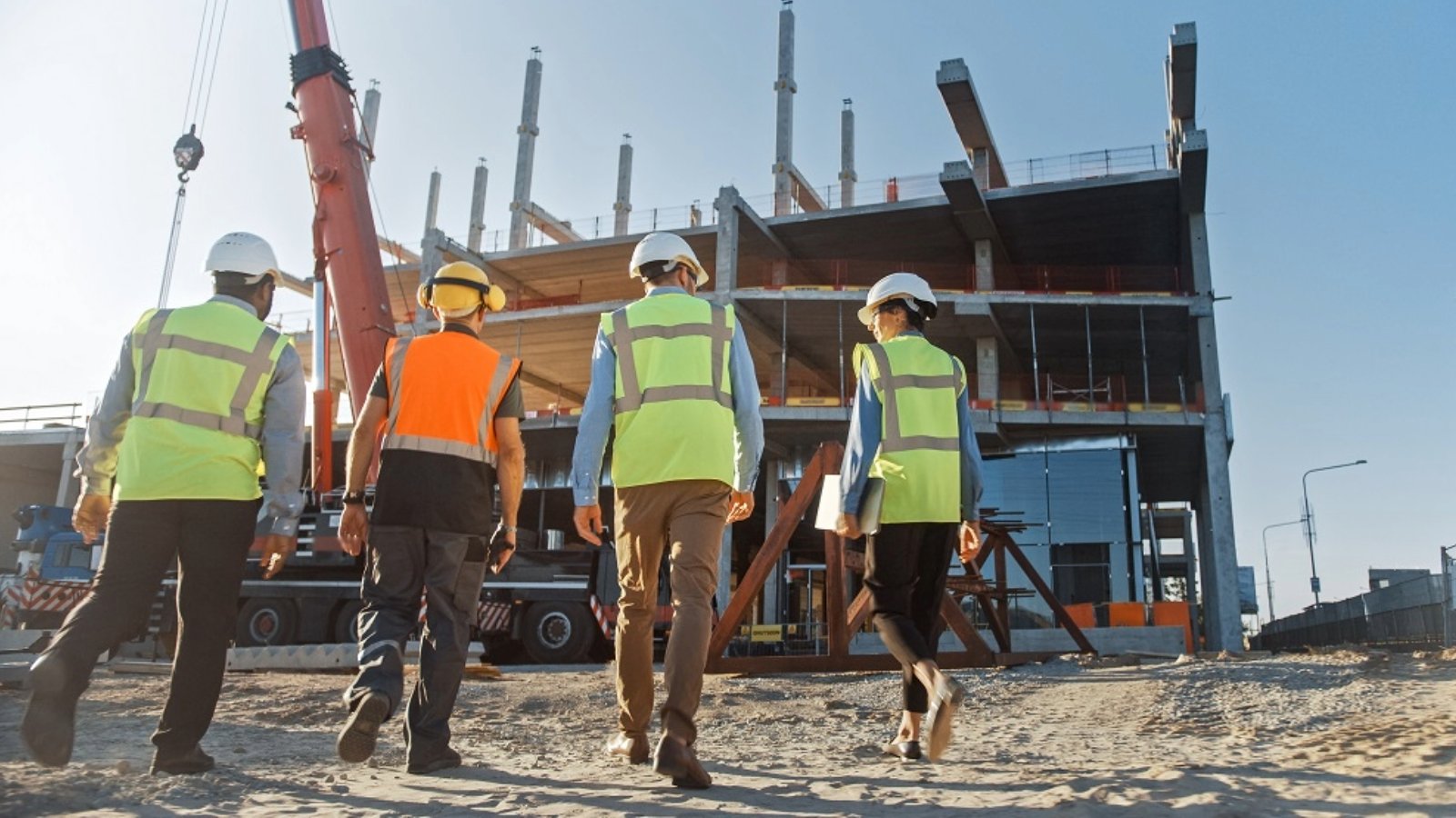 4 people wearing HiVis and safety helmets on a construction site
