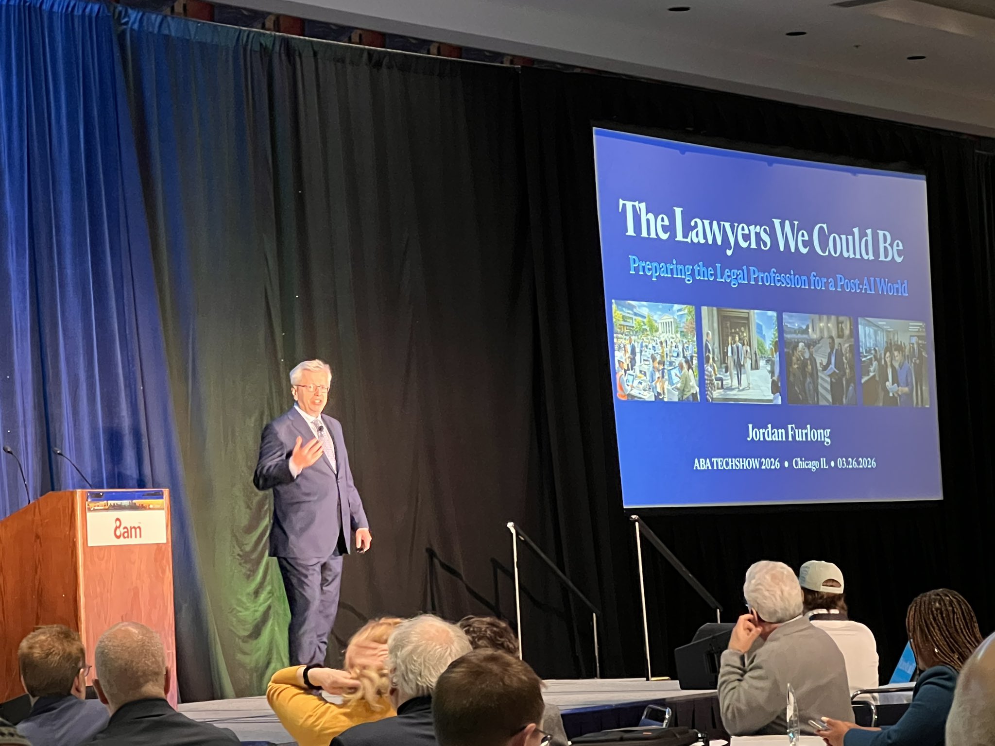 Jordan Furlong on stage at ABA TECHSHOW speaking next to a podium and his replayed slide deck with title “The Lawyers We Could Be”
