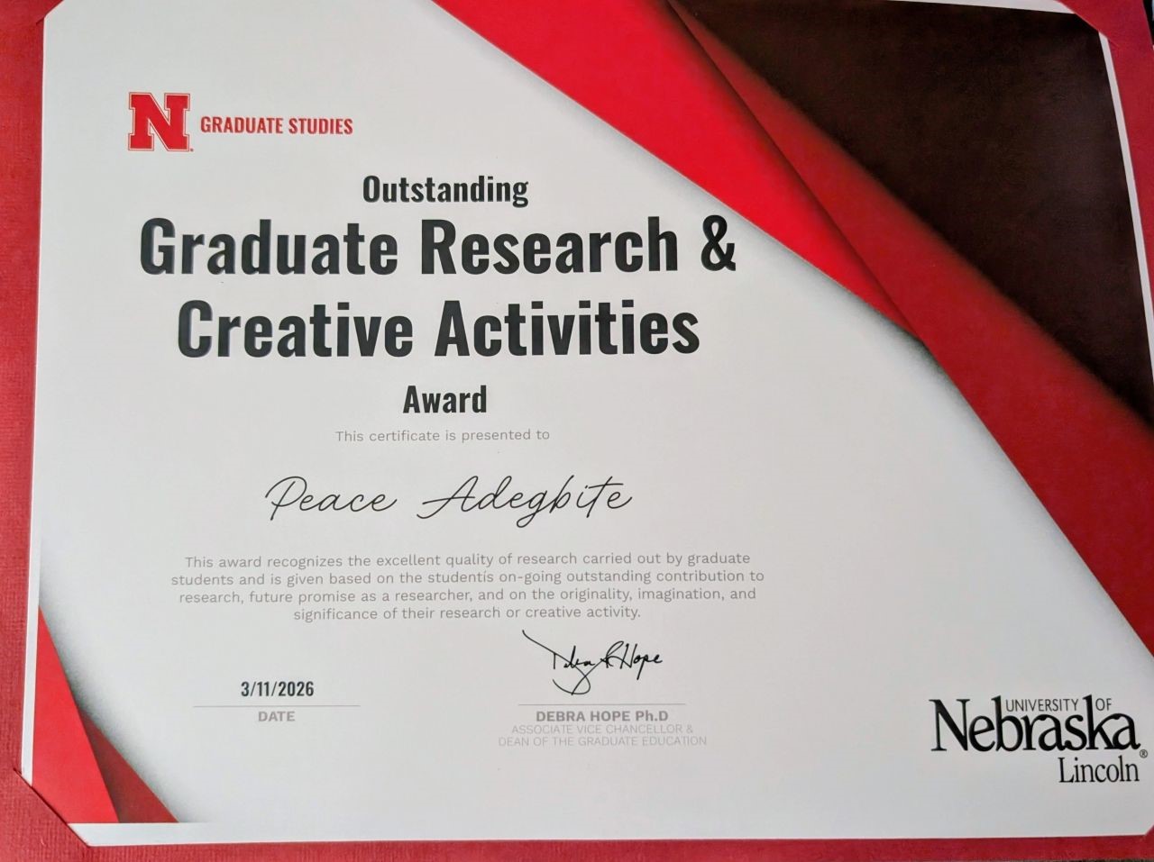 certificate from University of Nebraska-Lincoln Graduate Studies:
Outstanding Graduate Research & Creative Activities Award presented to Peace Adegbite, 3/11/2026, signed by Debra Hope, Ph.D.
