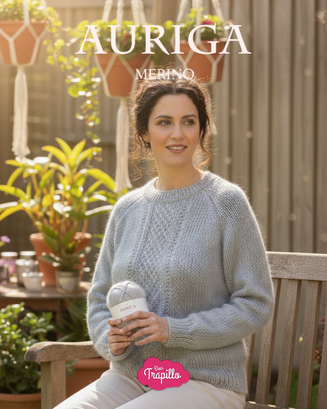 Mujer en jardín con jersey gris, sosteniendo un ovillo etiquetado Auriga Merino.