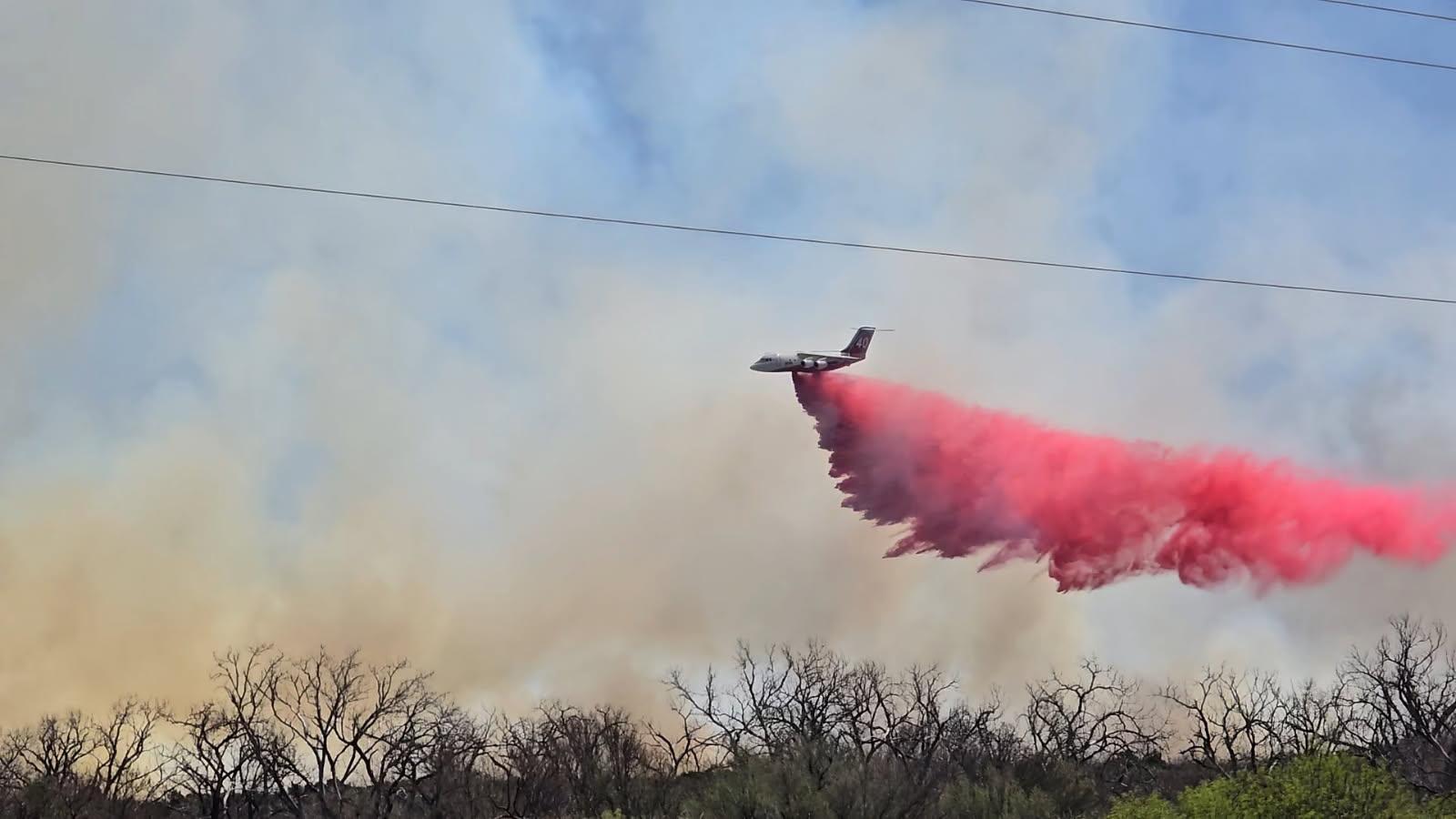 Bell Fire, Texas. Photo from InciWeb. An airtanker drops pink/red retardant near wildfire burning in Texas. 