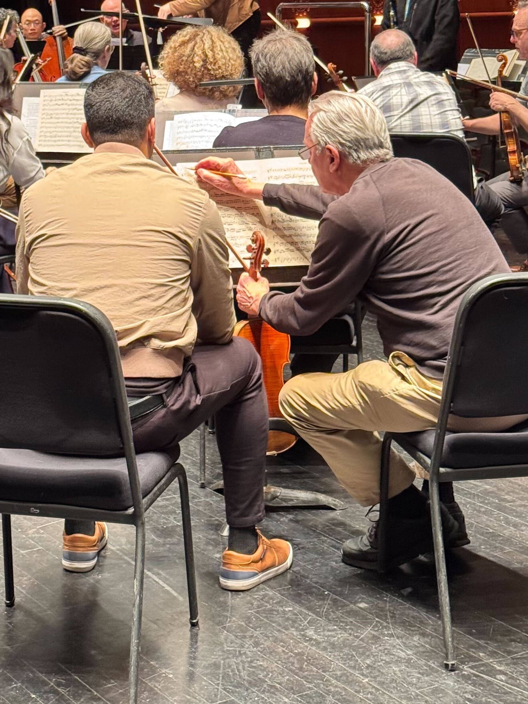 New Jersey Symphony musicians marking up sheet music during rehearsal.