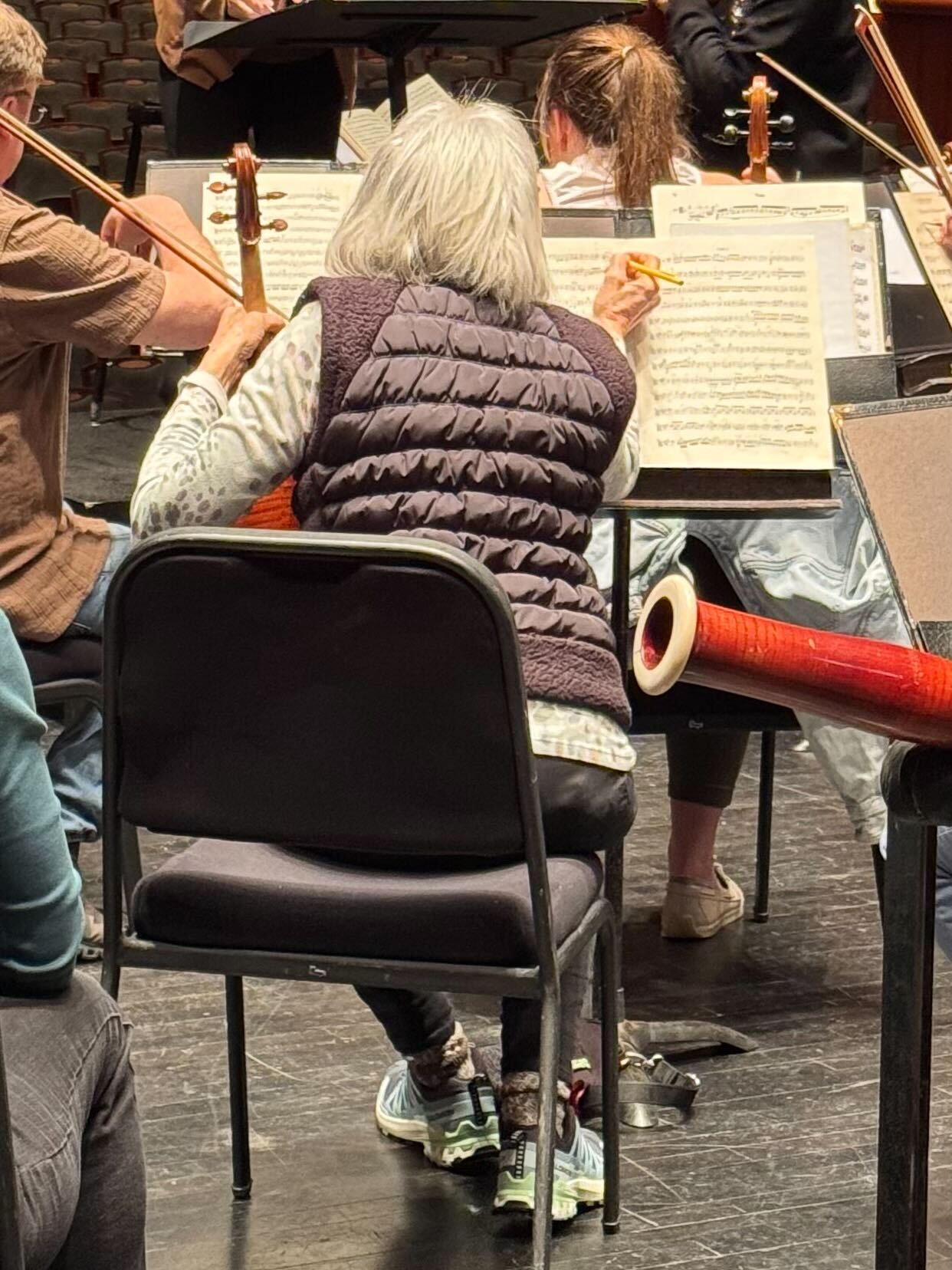 A New Jersey Symphony string musician marking up sheet music during rehearsal.