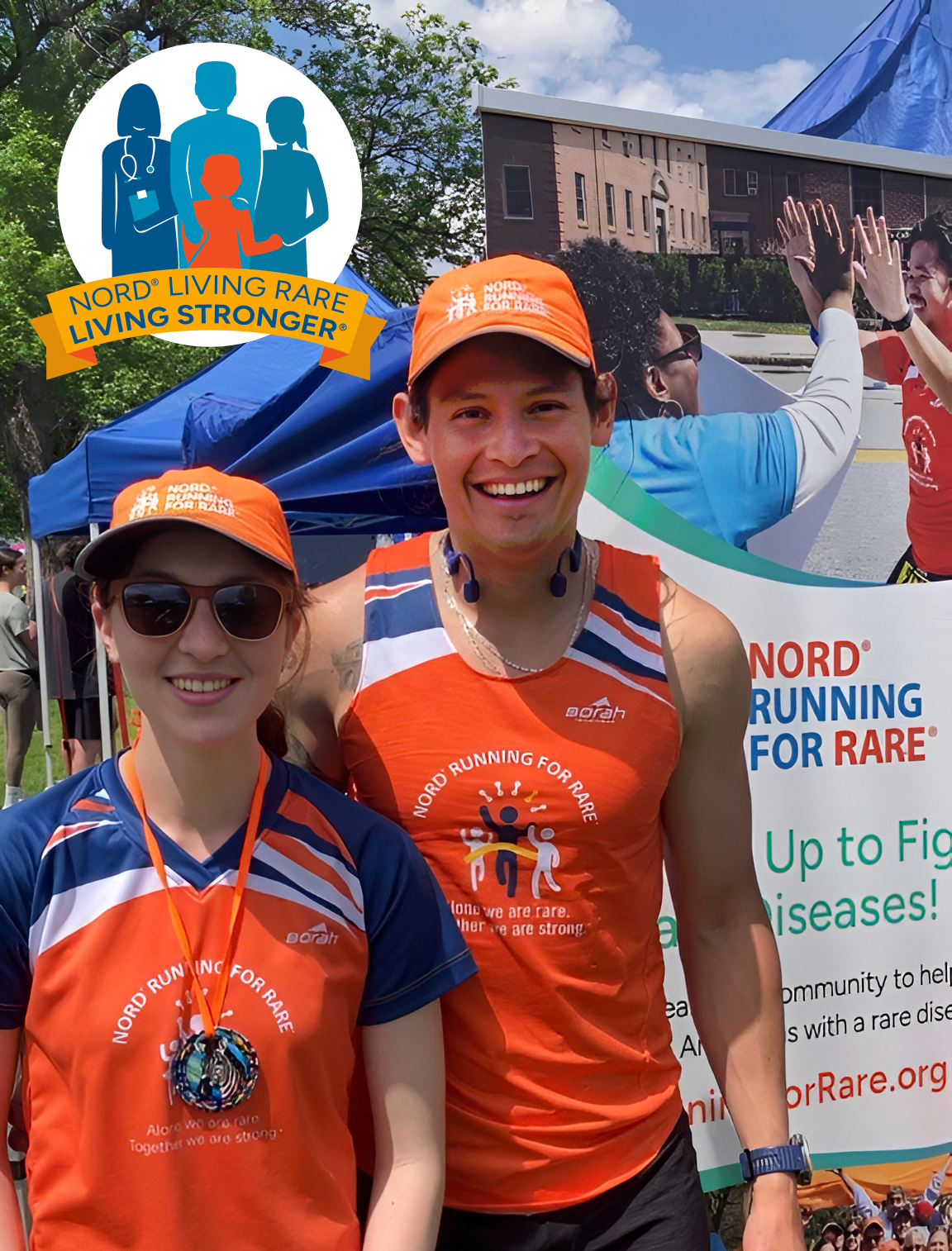 Two smiling individuals wearing matching "Nord Running for Rare" gear, including orange hats and shirts, stand in front of a booth at an outdoor event. A banner behind them promotes Nord's cause with slogans about supporting rare diseases.