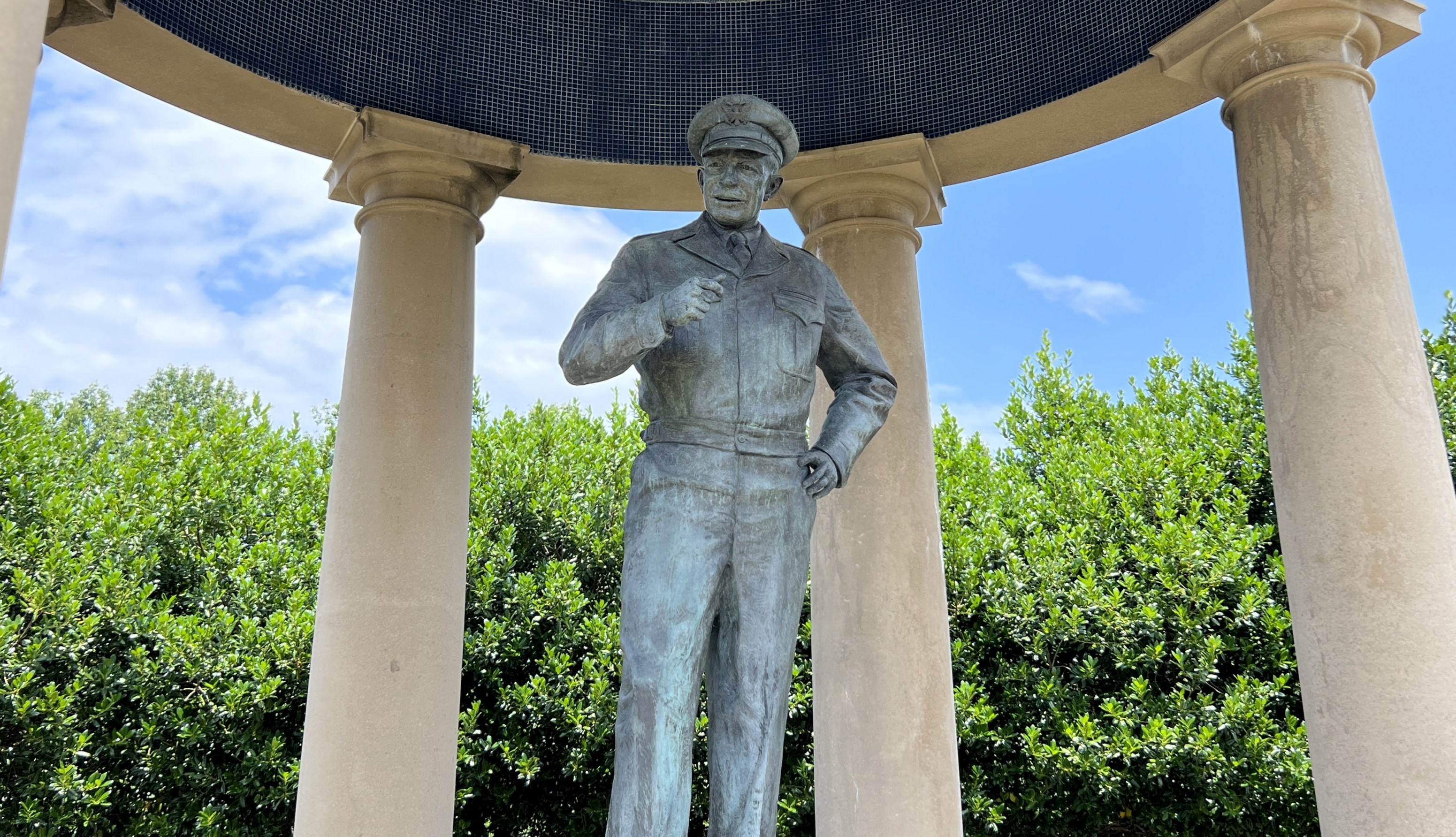A color photo of a statue inside a “folly” with a domed roof and pillars. 