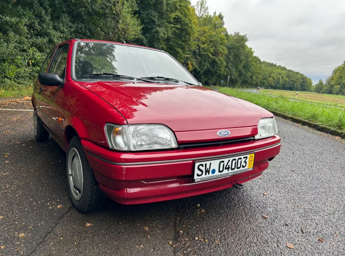 Der Kleinwagen mit dem freundlichen Gesicht von halb vorne: Stoßfänger in Wagenfarbe, dunkelgraue Zierleiste, geschlossene Front mit flachen Luftschlitzen, weiße Blinkergläser