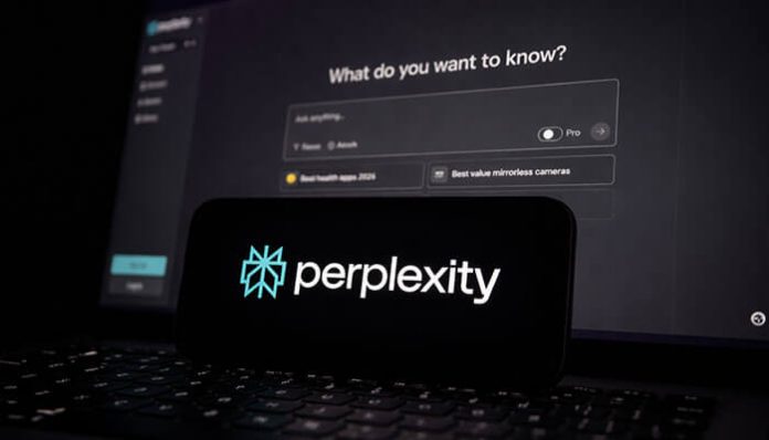 Perplexity AI logo displayed on a smartphone screen, with the platform's search interface visible on a laptop screen in the background, showcasing AI-powered research capabilities.