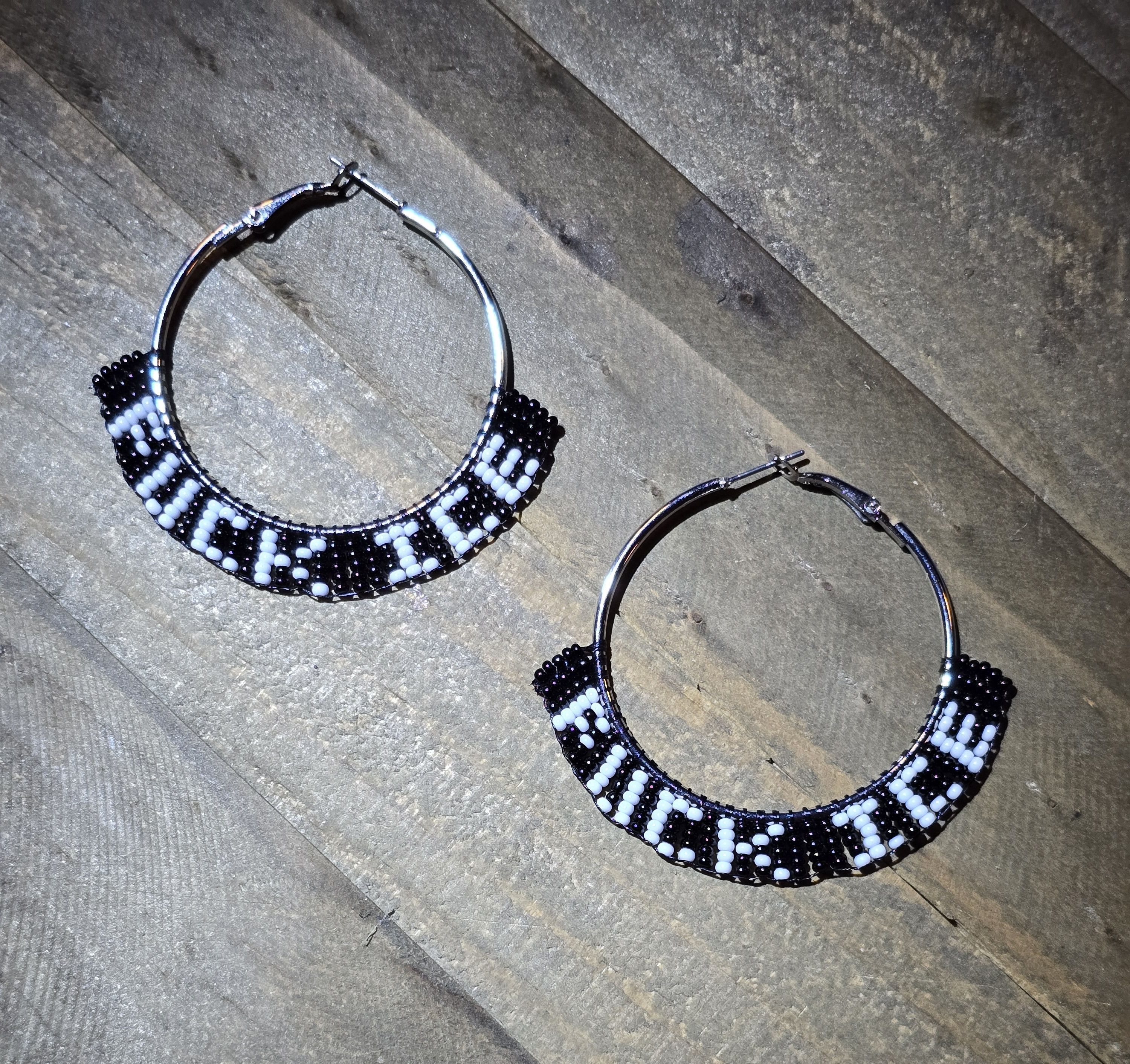 beaded silver-tone hoop earrings, black background with white lettering that spells F U C K I C E