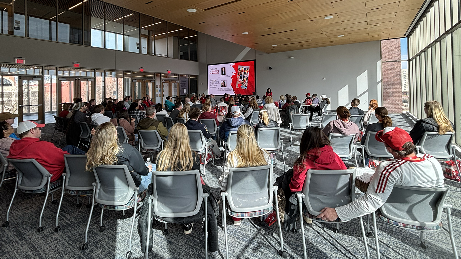 room full of students and their families listen as Loukia Sarroub presents about the elementary and secondary education programs